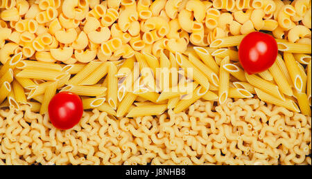 Food background from three types of pasta: Penne pasta, Chifferi pasta, Callentani pasta, and two Cherry tomatoes on the top Stock Photo