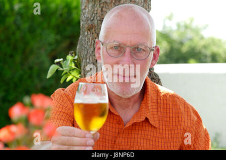 a mature man drinking a beer outside Stock Photo