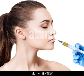 Beautiful woman gets injection in her lips. Isolated over white background. Plastic surgery and beauty concept. Stock Photo