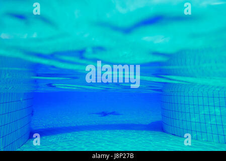 Background underwater light patterns in clear swimming pool. Stock Photo