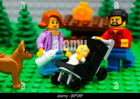 Tambov, Russian Federation - September 21, 2016 Lego family - father, mother and baby in stroller, on picnic in park with dog. Studio shot. Stock Photo