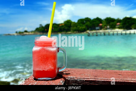 Watermelon smoothies in glass bottle from beach drink bar  photo in outdoor sun lighting. Stock Photo