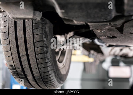 front car suspension. the garage mechanic raised the car on the lift Stock Photo