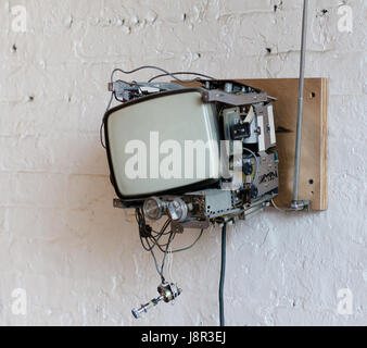 Old Television removed from case and mounted on brick wall in Hipster Loft in Dumbo Brooklyn. Stock Photo