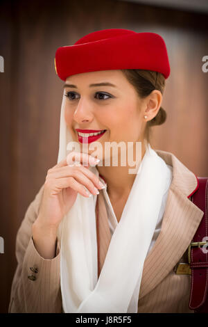 Young attractive Emirates cabin crew and flight attendant at London Heathrow Airport awaiting Emirates Airline A380 flight to Dubai Stock Photo