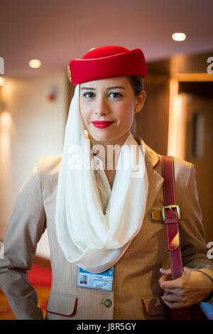 Young attractive Emirates cabin crew and flight attendant at London Heathrow Airport awaiting Emirates Airline A380 flight to Dubai Stock Photo