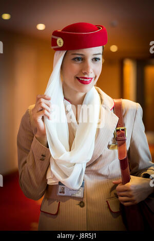 Young attractive Emirates cabin crew and flight attendant at London Heathrow Airport awaiting Emirates Airline A380 flight to Dubai Stock Photo