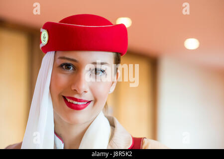 Young attractive Emirates cabin crew and flight attendant at London Heathrow Airport awaiting Emirates Airline A380 flight to Dubai Stock Photo