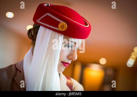 Young attractive Emirates cabin crew and flight attendant at London Heathrow Airport awaiting Emirates Airline A380 flight to Dubai Stock Photo