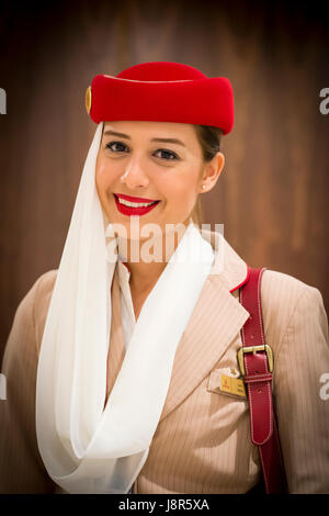 Young attractive Emirates cabin crew and flight attendant at London Heathrow Airport awaiting Emirates Airline A380 flight to Dubai Stock Photo