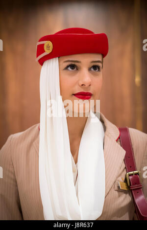 Young attractive Emirates cabin crew and flight attendant at London Heathrow Airport awaiting Emirates Airline A380 flight to Dubai Stock Photo