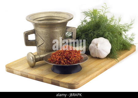 Still Life Spices, Immortin saffron ,marigold staminas in a copper vase on a wooden board on a background of a stern stupa for grinding spices, bunche Stock Photo