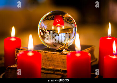 Crystal ball in the candle light to prophesy Stock Photo