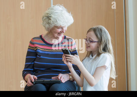 Picture: Moira Stephen 82 shown how to use a phone by Robyn Comrie Primary 6 pupils at Juniper Green Primary School Stock Photo