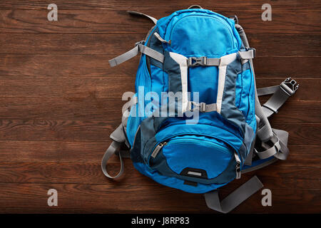 Top view of the blue outdoor backpack on the wooden background. Stock Photo