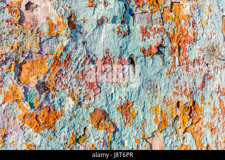 Close up of chipped peeling colorful paint on old wall Stock Photo