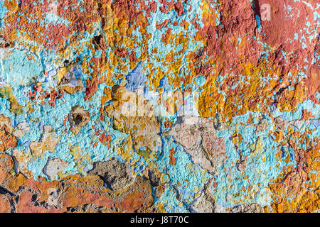 Close up of chipped peeling colorful paint on old wall Stock Photo