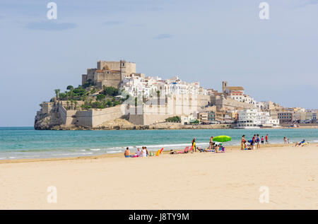 People on the soft sand beach of Playa Norte, overlooked by the old town and Papa Luna’s Castle, Peniscola, Spain Stock Photo