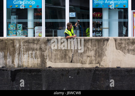 CARDIFF, UK - MAY 29 2017 Workman using pressure jet to clean wall. Man uses pressure washer to remove dirt from concrete surrounding Mermaid Key Stock Photo