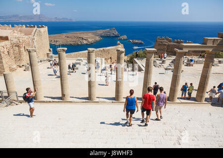 LINDOS, RHODES ISLAND, GREECE - September 3, 2015:   Tourists and visitors exploring  the colonnade of Grand Hellenistic Portico of the ancient Acropo Stock Photo