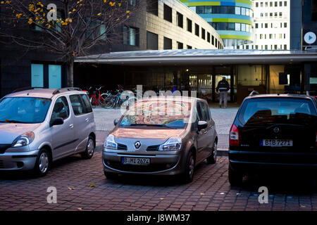 An office block is reflected in the window of a parked car in Berlin, Germany. Stock Photo