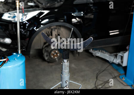 hydraulic Jack for the engine, and large auto parts. The car on the lift prepared to repair Stock Photo