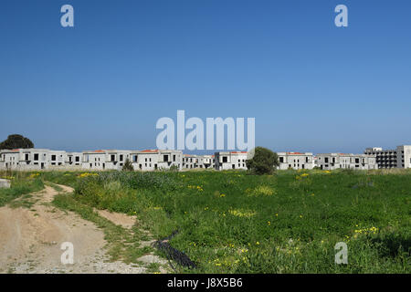 Lot of empty newly built houses in background and a blue sky outside the village Lapta in the North of Cyprus. Stock Photo