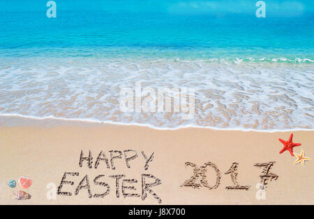 happy easter 2017 written on a tropical beach under clouds Stock Photo