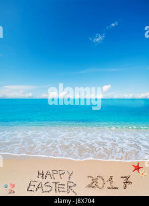 happy easter 2017 written on a tropical beach under clouds Stock Photo