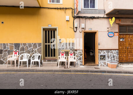Row of empty plastic chairs on the pavement outside houses and a restaurant in Fonsalia, Tenerife, Canary Islands, Spain Stock Photo