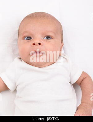 Mixed race south asian and caucasian newborn baby on white sheet Stock Photo