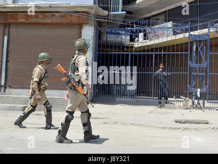 Srinagar, India. 30th May, 2017. A possee of Indian paramilitary personnel passes by a local during curfew in Kashmir. Curfew has been put in plcae in Kashmir on third day to counter the protests against the killing of Kashmiri Rebel Sabzar in an encounter with Indian Forces in Tral area of Kashmir on Saturday. Credit: Muzamil Mattoo/Pacific Press/Alamy Live News Stock Photo