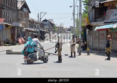 Srinagar, India. 30th May, 2017. An Indian paramilitary personnel stops a scooter from going beyond as curfew continues in Kashmir. Curfew has been put in plcae in Kashmir on third day to counter the protests against the killing of Kashmiri Rebel Sabzar in an encounter with Indian Forces in Tral area of Kashmir on Saturday. Credit: Muzamil Mattoo/Pacific Press/Alamy Live News Stock Photo