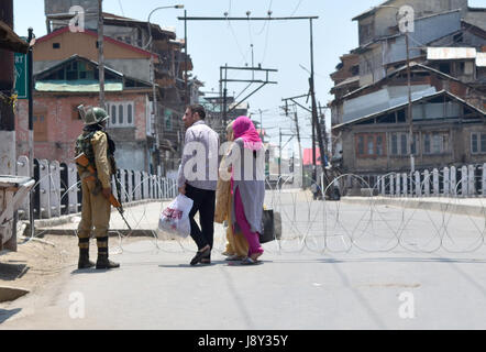 Srinagar, India. 30th May, 2017. An Indian paramilitary personnel questions a family during curfew in Kashmir. Curfew has been put in plcae in Kashmir on third day to counter the protests against the killing of Kashmiri Rebel Sabzar in an encounter with Indian Forces in Tral area of Kashmir on Saturday. Credit: Muzamil Mattoo/Pacific Press/Alamy Live News Stock Photo