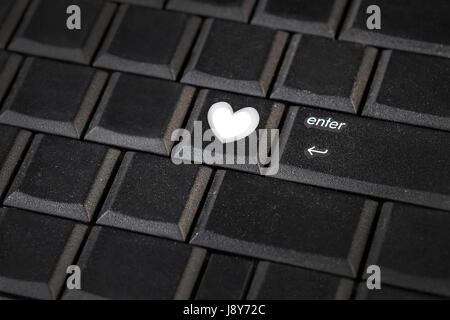 Close-up view on conceptual keyboard - Green key with heart symbol Stock Photo