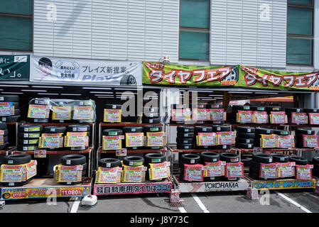Japanese tyre fitting shop, new tyres on display outside. Stock Photo