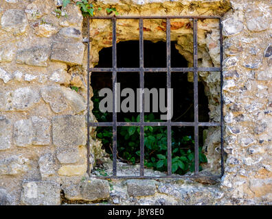 An ancient window in the thick stone walls of Wolvesley Castle the medieval palace of the Bishops of Winchester. Stock Photo