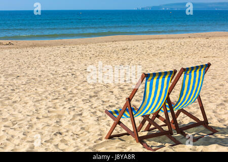 Two empty deckchairs on beach at Bournemouth in May Stock Photo