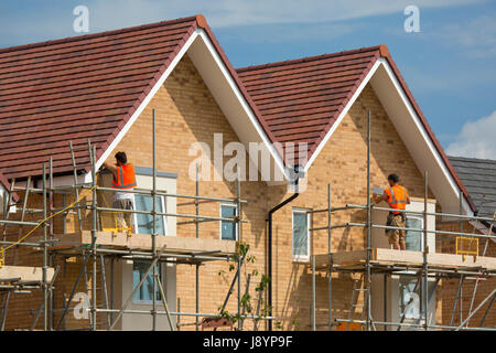 builders working on a new housing development on scaffolding Stock Photo