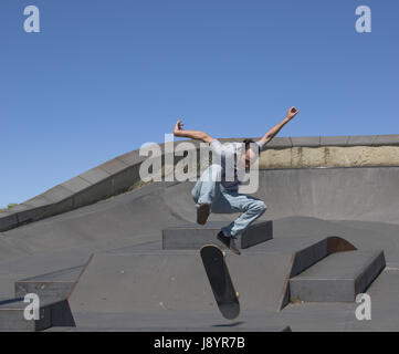 A skateboarder executing a kickflip  in the air Stock Photo