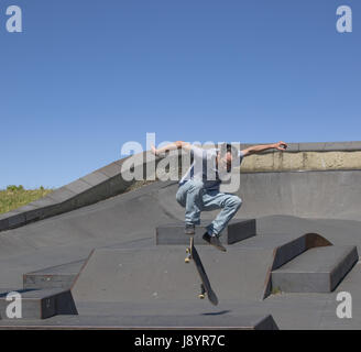 A skateboarder executing a kickflip  in the air Stock Photo