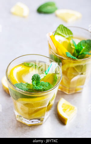 Homemade iced lemon sweet tea with mint on light gray table, delicious refreshment summer drink Stock Photo