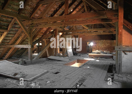 Old wooden roof beams on damaged garrett with wooden roof. The forgotten attic. Stock Photo