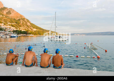 Omis, Croatia - August 17, 2016: Water polo reserve players watching the match in Omis, Croatia Stock Photo