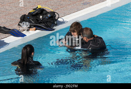 Two women learning scuba diving in a swimming pool, Lanzarote, Canary Islands Europe. Stock Photo