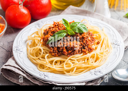 Spaghetti bologneseon white plate with ingredients on gray background Stock Photo