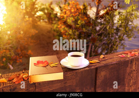3d rendering of cup of coffee on wooden windowsill with leaves in front of footpath in beautiful autumn sunlight Stock Photo