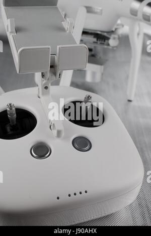 Big black and white hand aircraft controller, and quadcopter in background Stock Photo