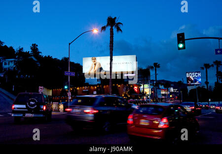 A fashion billboard lit up at dusk over traffic on the Sunset Strip in the west Hollywood neighborhood of Los Angeles, CA Stock Photo