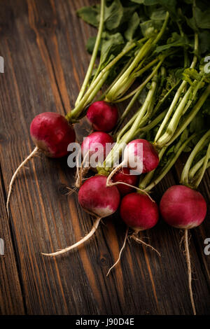 Freshly harvested red radishes on wooden background Stock Photo